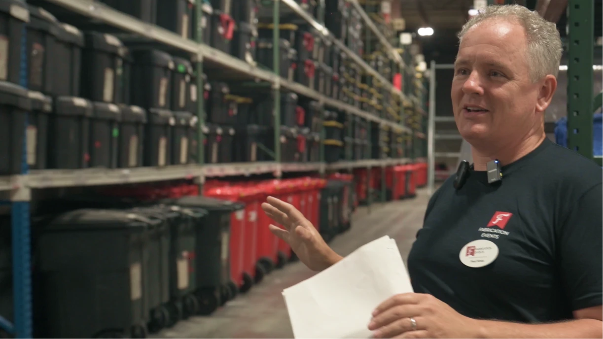 Organized event rental warehouse with labeled aisles and clear sections at Fabrication Events